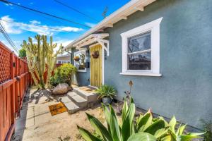 ein blaues Haus mit gelber Tür und einigen Pflanzen in der Unterkunft North Park Boho Bungalow by Rather Be Properties in San Diego