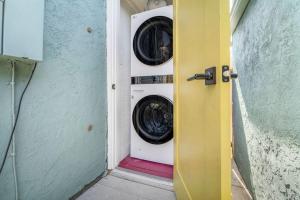 Waschmaschine und Trockner in einem Zimmer mit Tür in der Unterkunft North Park Boho Bungalow by Rather Be Properties in San Diego