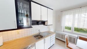 a kitchen with white cabinets and a sink at Ferienhaus Motorikpark in Gamlitz