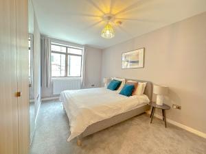 een slaapkamer met een groot bed met blauwe kussens bij Baker Street Apartments in Londen