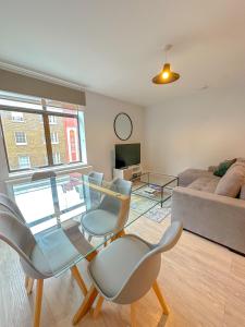 ein Wohnzimmer mit einem Glastisch und Stühlen in der Unterkunft Baker Street Apartments in London