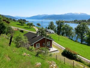 a small house on a hill next to a lake at Holiday Home Pærehagen by Interhome in Balestrand
