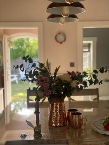 eine Vase mit Blumen auf dem Tisch in der Küche in der Unterkunft Bay Cottage wynajem domków in Swarzewo