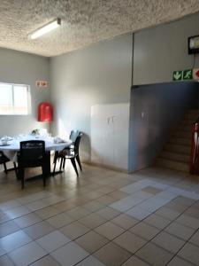 a dining room with a table and chairs and a staircase at Mabhida Guesthouse in Durban