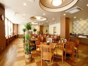 a dining room with wooden tables and chairs at Hotel Route-Inn Hamanako in Kosai