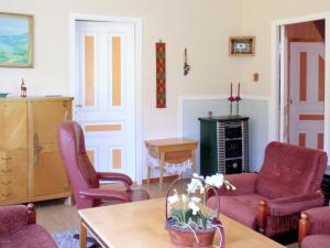 a living room with two chairs and a table at Holiday Home Nystølen by Interhome in Håvik +23 photos