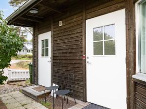 a wooden house with a white door and two chairs at Holiday Home Valbergsudden Utsikten by Interhome in Oskarshamn