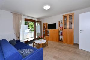 a living room with a blue couch and a tv at Familienfreundliches Gästehaus in Schopfheim nahe Basel, direkte S-Bahnverbindung in Schopfheim