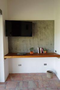 een flatscreen-tv aan de muur met een plankje bij Casa Vero in Villanueva