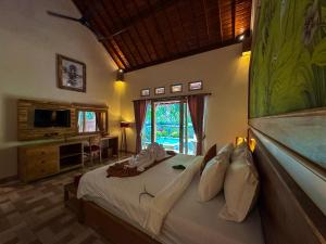 a bedroom with a bed and a television in a room at Prayatna Villas in Ubud +103 photos
