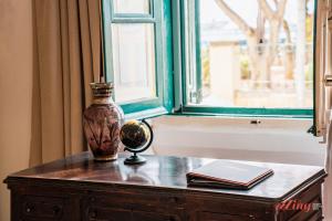 un tavolo con un vaso, un libro e una finestra di Elegant Holiday Home Near Valletta a Floriana Altre 13 foto