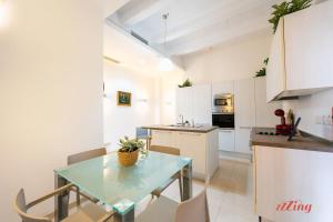 una cucina e una sala da pranzo con tavolo e sedie in vetro di Elegant Holiday Home Near Valletta a Floriana