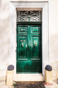 una porta verde su un edificio con due piante di Elegant Holiday Home Near Valletta a Floriana