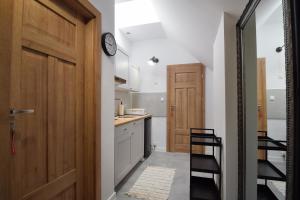 a kitchen with a door leading into a hallway at Apartamenty Przy Bałtyckiej in Mrzeżyno