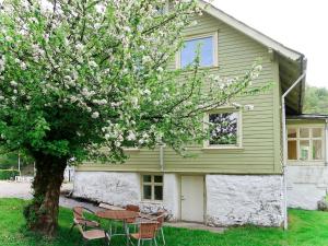 a table and chairs under a tree in front of a house at Holiday Home Greenhouse by Interhome in Onarheim