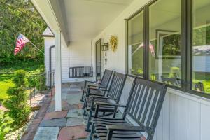 a row of chairs sitting on the front porch of a house at Stunning Waterfront Home with Hot Tub Deck Fire Pits and Office in Dennis