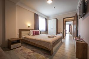 a bedroom with a large bed with pink pillows at Boulevard Apartments in Gevgelija