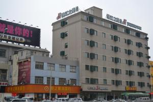 um edifício alto com um sinal em cima em Jinjiang Inn Wuhan Hankou Raiway Station em Wuhan