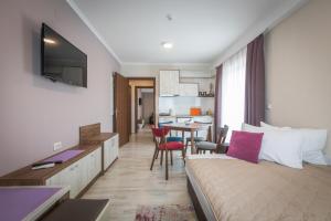 a room with a bed and a table with chairs at Boulevard Apartments in Gevgelija