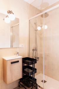 马德里Bravo Murillo Apartment的带淋浴的浴室，水槽旁边有一张黑色凳子