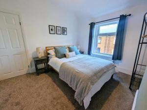 een slaapkamer met een bed en een raam bij Homely 3 Br House Perfect For Family And Friends in Gateshead