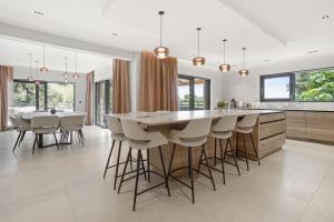 a kitchen with a large island with bar stools at Villa Belenos Piscine vue mer in Saint-Peïre-sur-Mer
