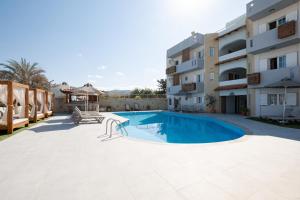 a swimming pool in front of a building at Dimitra Hotel & Apartments by Omilos Hotels in Kokkini Khanion
