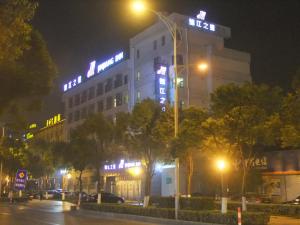 無錫市にあるJinjiang Inn Wuxi Liangxi Road Wanda Plazaの夜間ネオンの看板が貼られた建物