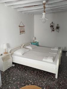 a white bed in a white room with a lamp at Στου Βάρδα, Χώρα, Σέριφος in Serifos Chora