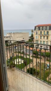 a balcony with a view of a street and buildings at Menton centre Vue imprenable sur mer et jardin Biovès in Menton