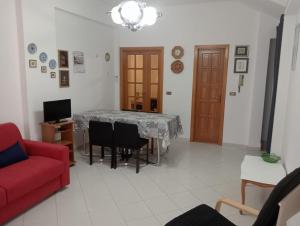 a living room with a red couch and a table at casa del corso in Canicattini Bagni