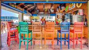 a group of colorful chairs sitting at a bar at Castle 1527 Studio Balcony with Oceanfront, Pools, Free Parking and Direct Beach Access in Miami Beach