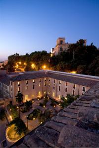 a view of a building with a courtyard at night at Donna Camilla Savelli - VRetreats in Rome