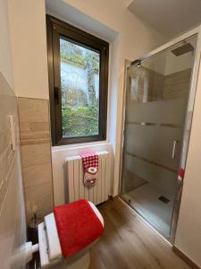 a small bathroom with a shower and a red stool at Casa alla Rocca in Clusone +2 photos