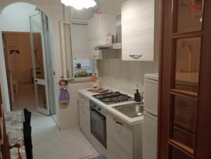 une petite cuisine avec une cuisinière et un évier dans l'établissement casa del corso, à Canicattini Bagni 6 autres photos
