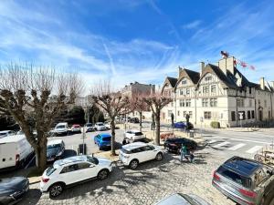 Un estacionamiento con autos estacionados frente a un edificio. en Forum Champagne grand T2 climatisé vue Cathédrale, en Reims