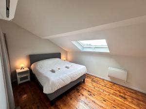 Un dormitorio con una cama y una claraboya. en Forum Champagne grand T2 climatisé vue Cathédrale, en Reims