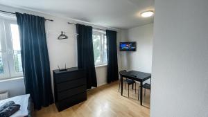 a bedroom with a desk and a table with a computer at Apartments Halle West in Nietleben