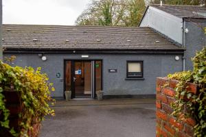 a gray building with a door and a window at The Enniskillen Hotel and Motel in Enniskillen