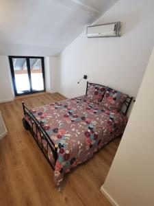 a bedroom with a bed with a floral comforter at gites des ammonites in Montalieu-Vercieu +2 photos