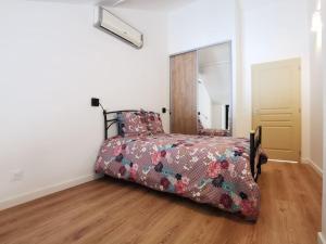 a bedroom with a bed with a floral comforter on it at gites des ammonites in Montalieu-Vercieu