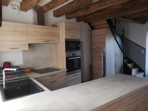 a kitchen with wooden cabinets and stainless steel appliances at Maison de charme 13 couchages in Marigné