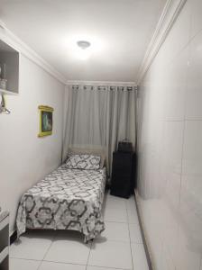 mała sypialnia z łóżkiem w pokoju w obiekcie Casa com piscina perto do Parque do Povo w mieście Campina Grande