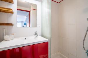 une salle de bain avec une armoire rouge et un miroir dans l'établissement Maison 38m2 proche de la mer, à Gruissan 13 autres photos
