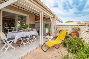 een patio met een tafel en stoelen erop bij Maison 38m2 proche de la mer in Gruissan