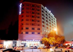 ein Hotelgebäude mit davor geparkt in der Unterkunft Jinjiang Inn Tiayuan Yingze Park in Taiyuan
