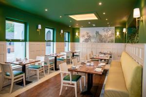 a restaurant with wooden tables and chairs and green walls at The Enniskillen Hotel and Motel in Enniskillen