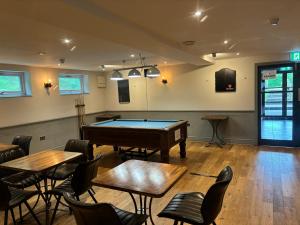 a room with a pool table and tables and chairs at Aleppo Merchant Inn in Carno
