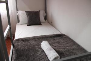 a small room with a bed with a pillow at Crew Hostel Tirana in Tirana