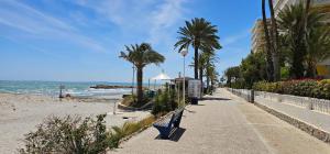 a sidewalk next to a beach with palm trees at A 150 metros del Mar, Parking Gratis, AC in Santa Pola